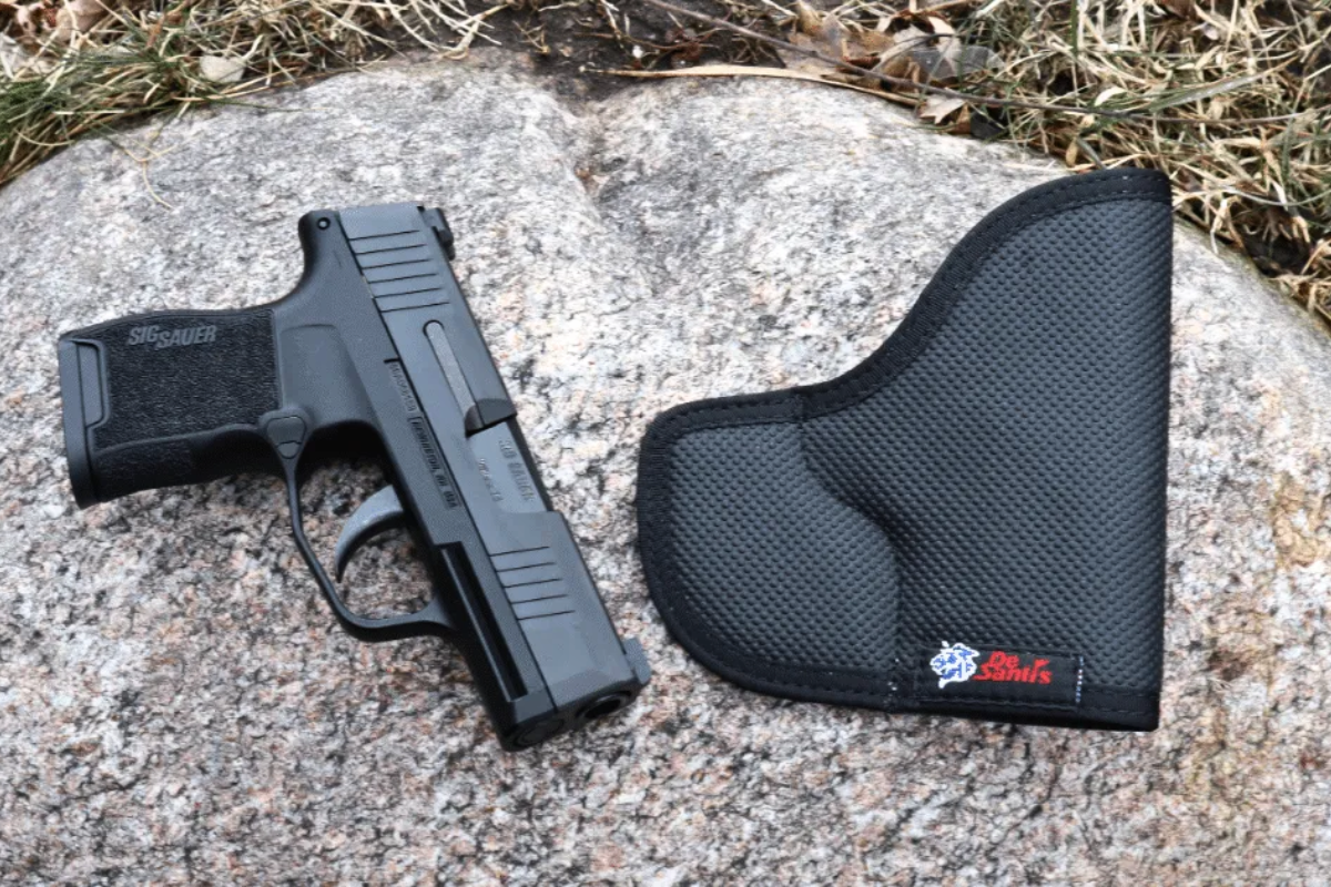 DeSantis Pocket holster on ground next to a Sig Sauer P365 while being tested.
