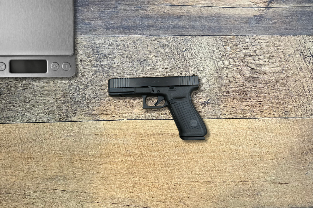 Glock 21 Gen 5 on desk next to scale to weigh.